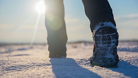Schoenen die door sneeuw lopen. 
