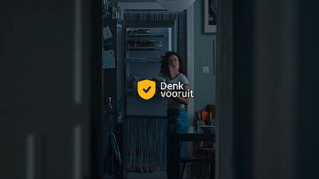 De persoon staat voor een open koelkast waarvan de elektriciteit niet werkt. Dezelfde persoon kijkt naar een lamp die het niet doet, omdat de elektriciteit is uitgevallen. 